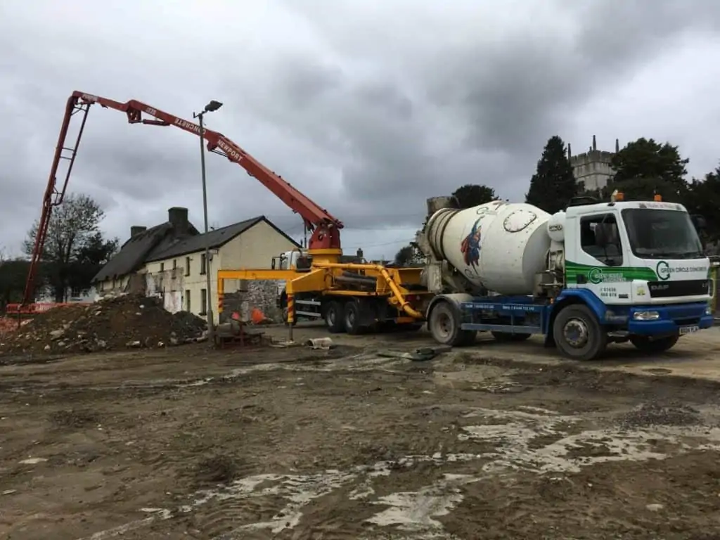 Small drum dispensing concrete into pump